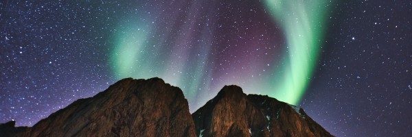 mountains against a night sky with green and purple northern lights