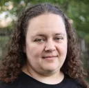 photo of Janet Callahan - female presenting, long curly brown hair