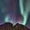 mountains against a night sky with green and purple northern lights