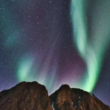mountains against a night sky with green and purple northern lights
