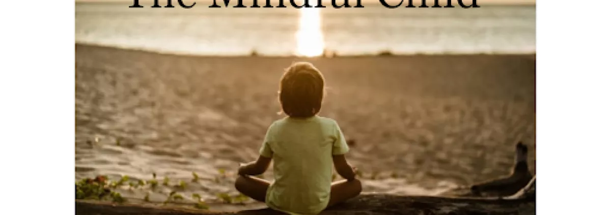 A child is meditating on the beach at sunset